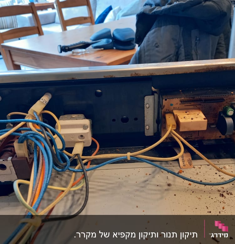 חוטי חשמל מחוברים ללוח בקרה של מקרר